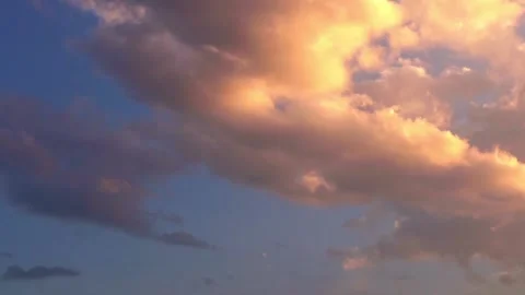 Time lapse clouds with yellow orange sunlight at sunset on blue sky Stock Footage 138834225
