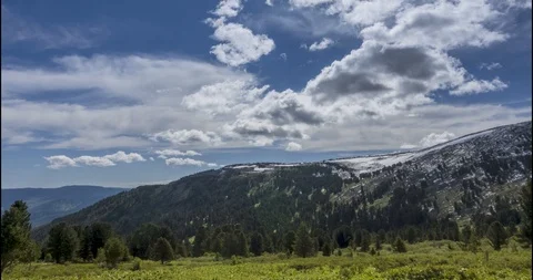 Time lapse of cloudscape behind of the mountains top. Snow, rocks, cliffs and Stock Footage 113638335