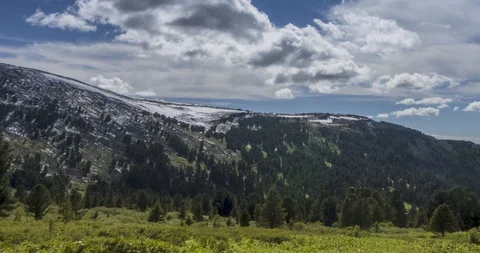 Time lapse of cloudscape behind of the mountains top. Snow, rocks, cliffs and Stock Footage 128231871