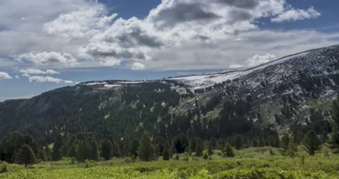 Time lapse of cloudscape behind of the mountains top. Snow, rocks, cliffs and Stock Footage 134477956
