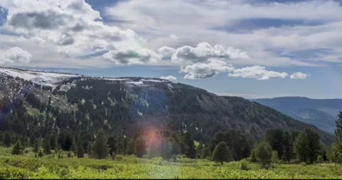 Time lapse of cloudscape behind of the mountains top. Snow, rocks, cliffs and Stock Footage 151296763