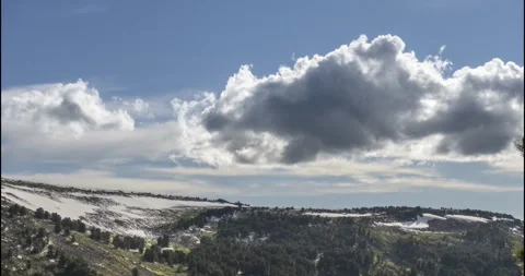 Time lapse of cloudscape behind of the mountains top. Snow, rocks, cliffs and Stock Footage 311554434