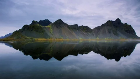 Time Lapse - Cloudscape moving over mountains with perfect reflection Stock Footage 69871108