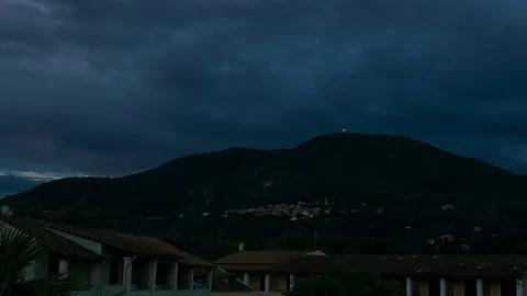 Time lapse of cloudy dawn over a mountain town Stock Footage 70363404