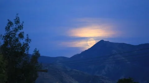 Time Lapse of Cloudy Full Moon Rise over Mountains. Stock Footage 48572702