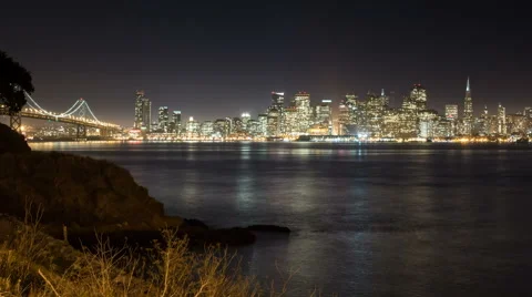 Time lapse of cloudy San Francisco shoreline and the bay bridge at night Stock Footage 43297916