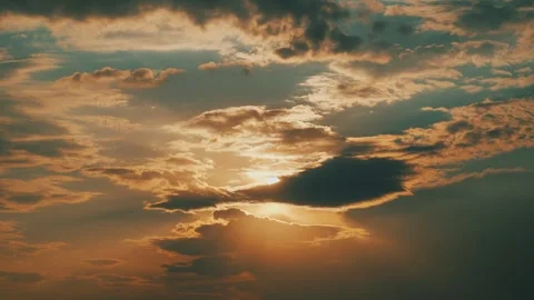 Time lapse of cloudy sky with bright golden sun and soft clouds at sunset. Видео 337563996