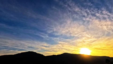 Time lapse of cloudy sun set with hills and planes Stock Footage 315782862