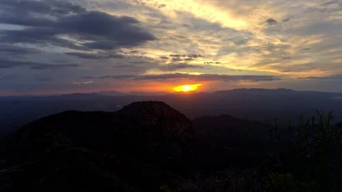 Time lapse of colorful clouds and sun rays over a desert valley Stock Footage 340408016