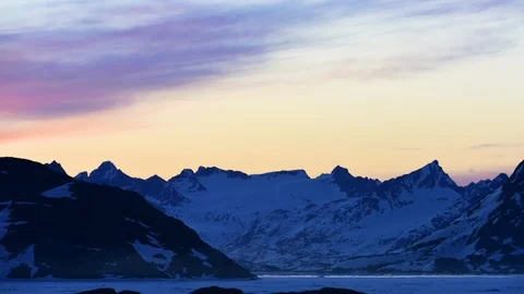 Time-lapse of colorful clouds over icy mountains, day to night Stock Footage 113268107