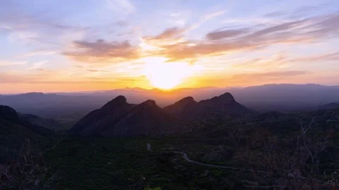 Time lapse of a colorful sunset beyond 4 rugged mountain peaks Video stock 240768268