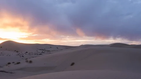 Time lapse of colorful sunset clouds over sand dunes Stock Footage 86430623