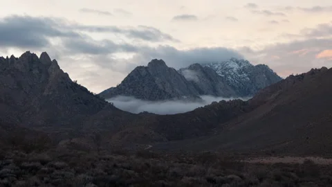 Time lapse of colorful sunset clouds above snowy mountains in the Sierra Nevada Stock Footage 144973143