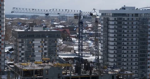 Time lapse of construction site, tower crane sways in wind, winter construction Stock Footage 128972100