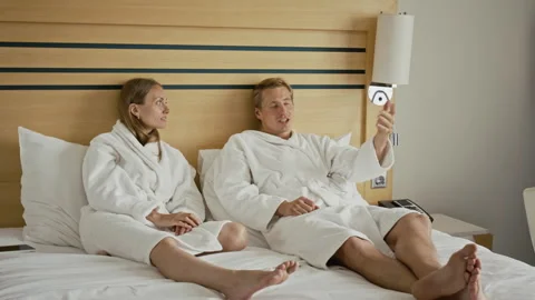 Time Lapse of Couple Watching Television with Remote Control in Hotel Bed Stock-Footage 345835112