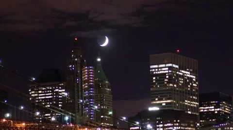 Time-lapse of the crescent moon in Manhattan with pan over the Brooklyn Bridge Video stock 64271051