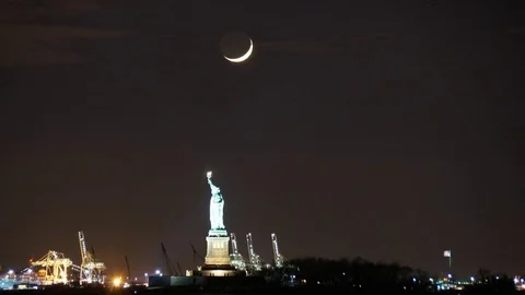 Time-Lapse of the Crescent Moon Seting over the Statue of Liberty in NYC Stock Footage