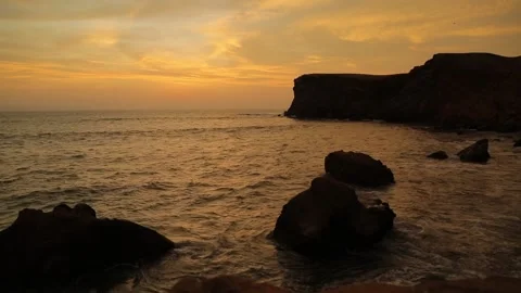 Time lapse of Crimson sunset, waves, tide in the ocean coming between two rocks. Stock Footage 202526229