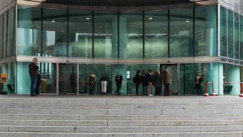 Time lapse of crowd of people walking and standing near entry doors of an office Stock Footage 85233013