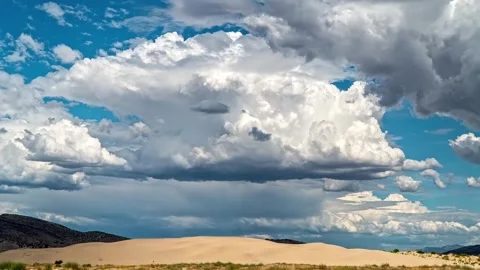 Time lapse of cumulus clouds moving over sand dunes and mountain peaks. Stock Footage 341068537