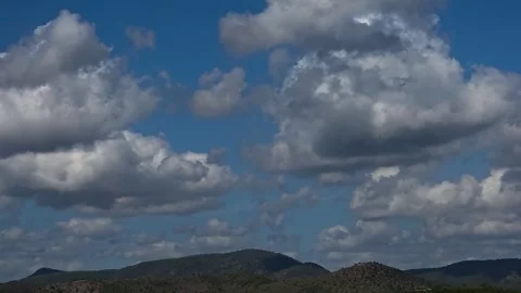 Time lapse of cumulus clouds moving fast over green mountains and agricultur Stock Footage 345365544