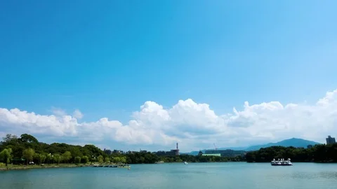 Time lapse of cumulus crowds growing over lake in public park Stock Footage 78978427