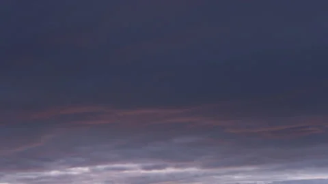 Time lapse of dark clouds that bust into a colorful display at sunrise Stock Footage 235932120