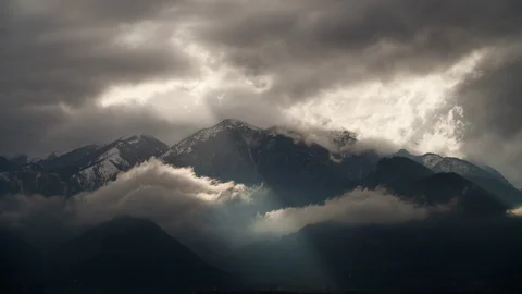 Time-lapse of dark clouds floating over snow covered mountain peaks Видео 113223319