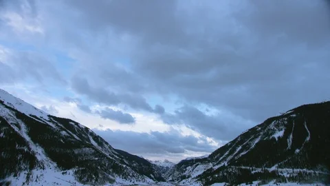 Time-lapse of dark clouds floating over snow-covered mountains Stock Footage 116786081