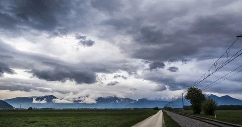Time lapse of dark clouds gathering above, next to a train track with a Stock Footage 109301684