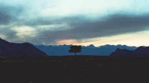 Time-lapse of dark clouds moving over the silhouetted mountains Stock Footage 113200476