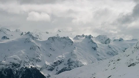 Time-lapse of dark clouds moving over snowy mountains at dusk Stock Footage 113254605