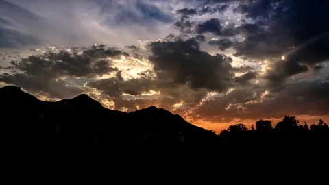 Time lapse of dark clouds rolling over the mountains during sunset Stock Footage 77815079