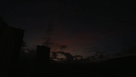 Time-lapse of dark clouds rolling over skyscrapers during sunrise Video stock 117715064