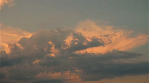Time-lapse dark cumulus and pink cirrus clouds move across evening sky at dusk Stock Footage 196921607
