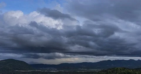 Time lapse of dark rainy clouds moving over hills and mountains Stock Footage 154194988