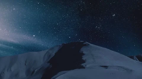 Time lapse of Dark starry night sky with stars moving over winter alps mountains Stock Footage 277399644