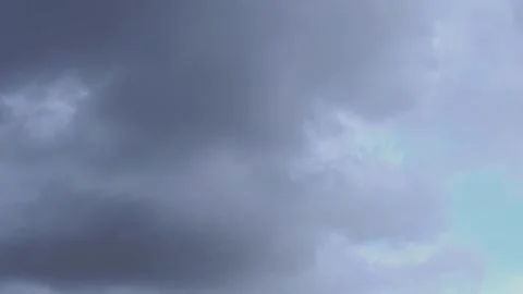 Time-lapse of dark storm clouds passing to reveal a bright blue sky Stock Footage 335372965
