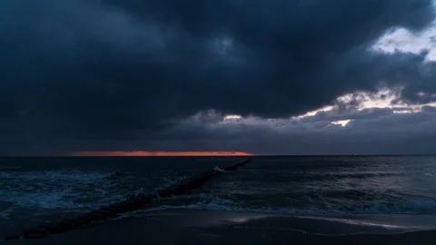 Time lapse of dawn at the beach with rain clouds and rainfall Stock Footage 107486686