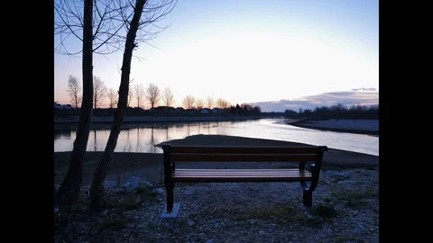 Time lapse of day comming by the riverand behind the benche Stock-Footage 128986927