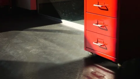 Time-Lapse of Daylight Passing Over Red Storage Cabinet on Office Floor Stock Footage 113875958