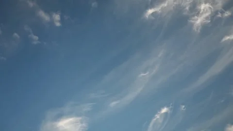 Time lapse of delicate white cirrus clouds drifting gracefully across a bright Stock Footage 329239310