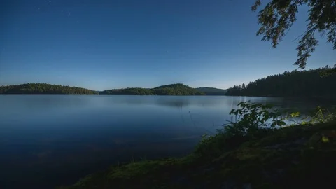 Time lapse dolly shot of moon lit lake at night with stars and mist Stock Footage 79691050