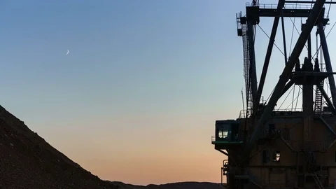 Time lapse of dragline excavator operating in mine at sanset with moving moon in Stock Footage 75408636