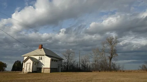 Time lapse of dramatic clouds above a 100-year-old prairie schoolhouse. Stock Footage 220452154