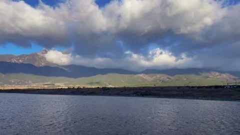 Time-lapse of Dramatic Clouds Rolling Over Mountain Range and Lake. Stock Footage 327828221