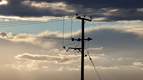 Time lapse of a dramatic cloudscape moving behind a wooden electricity pylon. UK Stock Footage 157919544