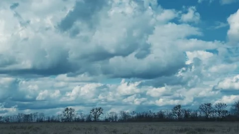 Time lapse of dramatic cumulus clouds in countryside over a field in autumn Stock Footage 237078320