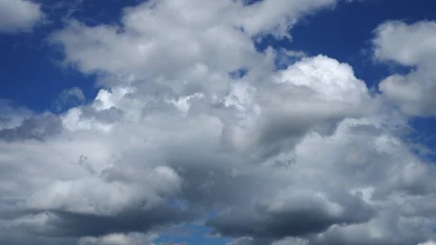 Time-lapse of Dramatic fluffy white clouds dancing across a vibrant blue sky Stock Footage 281054549