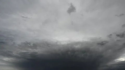Time lapse of dramatic gray storm clouds moving towards the viewer fill the sky Stock Footage 294256979
